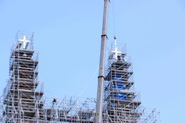 Deux croix ont été installées avec succès au sommet des deux tours de Cathédrale Notre-Dame de Saïgon, à une hauteur d’environ 60 mètres. Photo : VNA