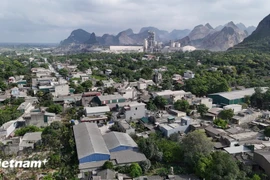 Un quartier résidentiel recouvert de fumée et de poussière causées par les activités d'extraction de pierre et de production de ciment. Photo : VietnamPlus