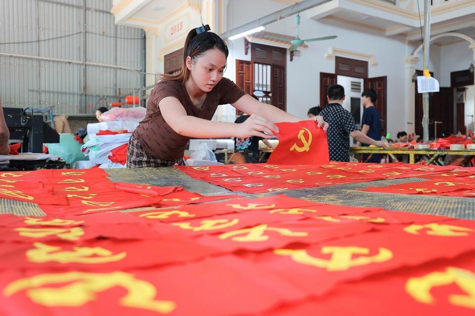 De génération en génération, les artisans de Tu Van maintiennent vivante la tradition séculaire de broder et de coudre les drapeaux nationaux. Photo : Le Dong - VNA. Photo : Le Dong - VNA