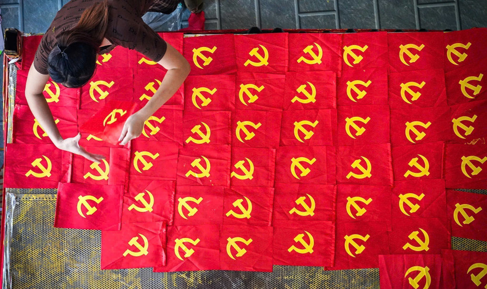 L'ambiance est animée dans le village de Tu Van où les familles sont en pleine effervescence pour la fabrication des drapeaux nationaux en vue de la Fête nationale du 2 septembre. Photo : Khanh Hoa - VNA
