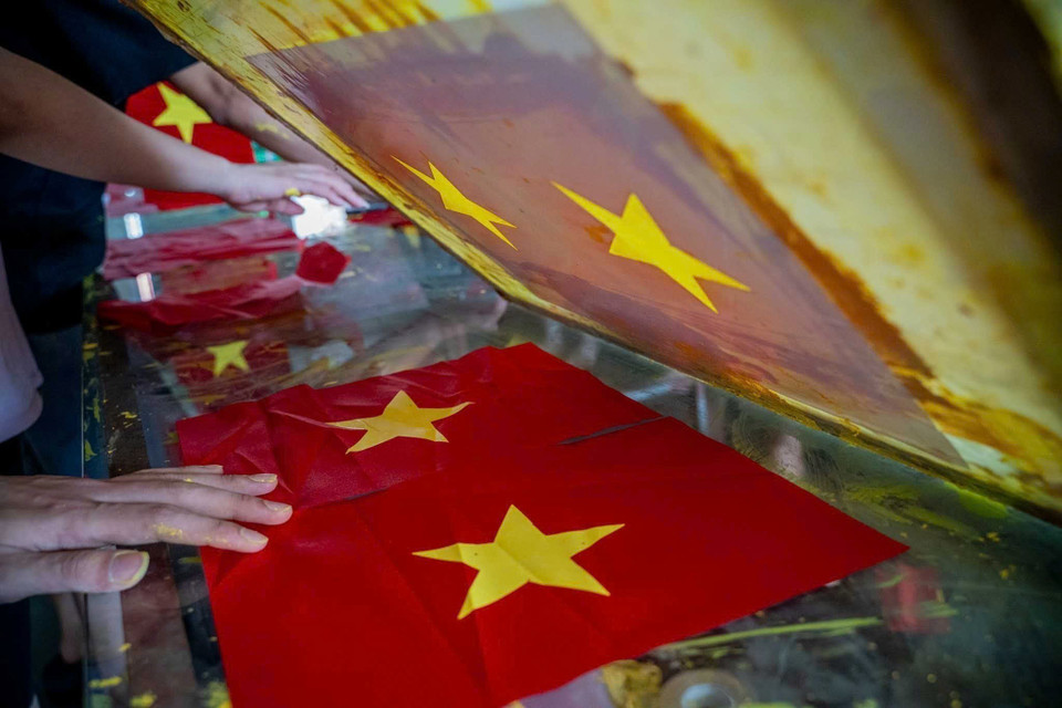 À l'approche de la Fête nationale du 2 septembre, une ambiance de production animée règne chez les familles du village de Tu Van qui se consacrent à la fabrication de drapeaux nationaux. Photo : Khanh Hoa - VNA