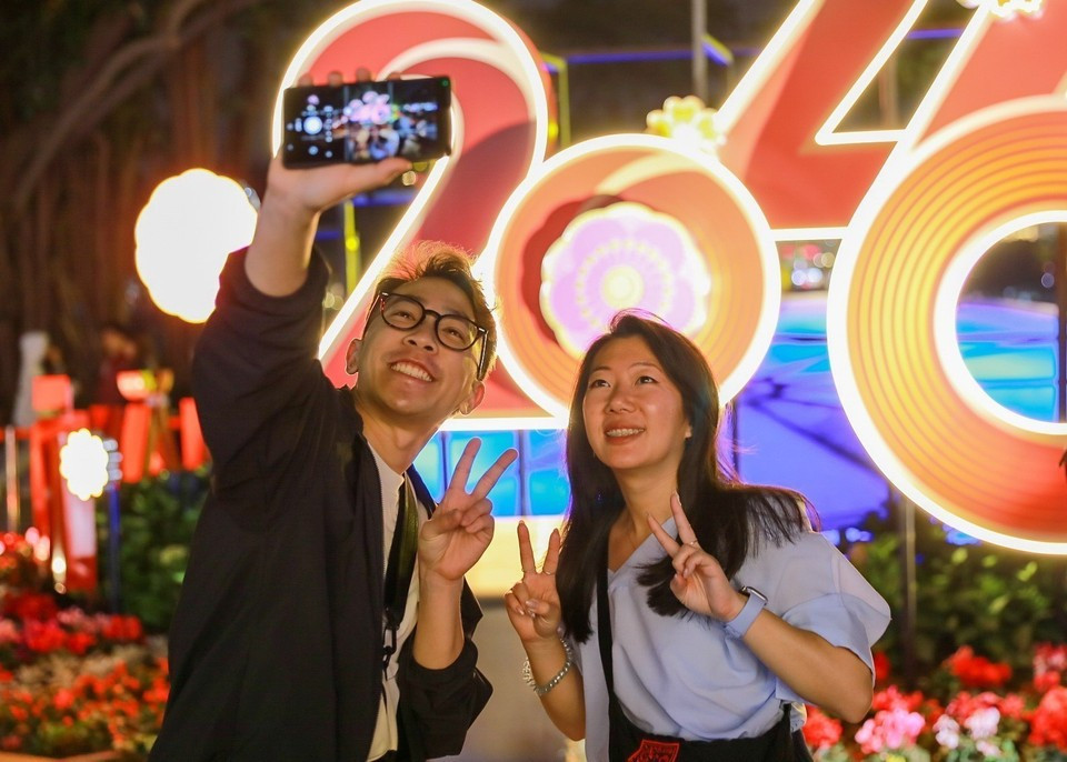 Des visiteurs étrangers immortalisent des moments à l’approche du Nouvel An 2026. Photo : VNA