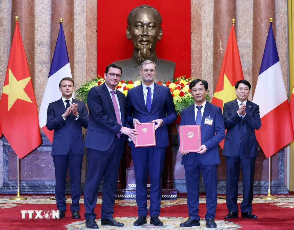 Le professeur, académicien Le Truong Giang, directeur adjoint de l'Académie des sciences et technologies du Vietnam, l'ambassadeur de France au Vietnam, Olivier Brochet (au nom du Centre national d'études spatiales-CNES) et Stéphane Vesval, responsable des ventes Systèmes spatiaux, Airbus Defence and Space échangent un procès-verbal de coopération conjoint entre l'Académie des sciences et technologies du Vietnam et Airbus Defense and Space (Airbus) et le CNES sur le déploiement de satellites d'observation de la Terre. Photo : VNA