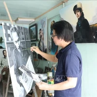 L'artiste Tran Hoa Binh peint le portrait de l'Oncle Ho. Photo : VNA