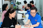 Des jeunes volontaires de Hàng Bồ (Hanoï) aident les habitants dans les démarches administratives en ligne. Photo : VNA