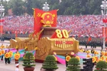 Un véhicule miniature portant l'emblème national de la République socialiste du Vietnam mène le défilé militaire et le cortège de masse. Photo : VNA
