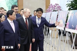 Le Premier ministre Pham Minh Chinh et le président russe, Vladimir Poutine, visitent une exposition de photos sur la coopération entre les deux pays. Photo: VNA