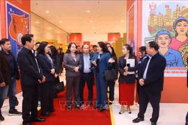 La vice-directrice générale de l’Agence vietnamienne d’Information (VNA), Nguyen Thi Su, présente à la vice-présidente Vo Thi Anh Xuan l'exposition photographique de la VNA dans le cadre du XIᵉ Congrès national d’émulation patriotique. Photo : VNA