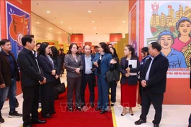 La vice-directrice générale de l’Agence vietnamienne d’Information (VNA), Nguyen Thi Su, présente à la vice-présidente Vo Thi Anh Xuan l'exposition photographique de la VNA dans le cadre du XIᵉ Congrès national d’émulation patriotique. Photo : VNA
