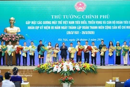Le Premier ministre Pham Minh Chinh offre des fleurs de félicitations aux jeunes Vietnamiens exemplaires. Photo : VNA