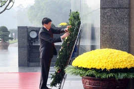 Le secrétaire général du PPRL et président lao Thongloun Sisoulith, rend hommage au Président Hô Chi Minh en son mausolée. Photo: VNA