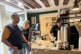 Des Français se rendent chez “PHIN MI” pour déguster un café aux saveurs typiquement vietnamiennes. Photo: VNA