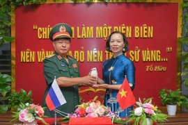 Le général Luu Trong Lu, président de l’Association des anciens combattants de la province de Diên Biên, remet l’urne contenant la terre sacrée à Vu Thi Tuyet Nga, directrice du Musée de la Victoire de Diên Biên Phu. Photo : VNA