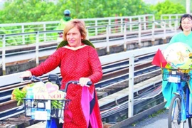 Stella Ciorra dans un périple à vélo pour promouvoir l'áo dài vietnamien. Photo : Journal Nhân Dân électronique