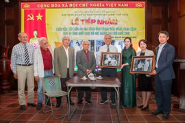 Des représentants de la famille de Pham Van Cong remet deux photos immortalisant la visite du Président Hô Chi Minh à leur domicile, lors du réveillon du Têt 1963. Photo: VNA