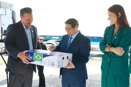 Le Premier ministre Pham Minh Chinh signe sur le premier lot de bœuf brésilien exporté vers le Vietnam. Photo : VNA