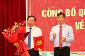 Nguyen Thanh Tam, membre du Comité central du Parti et vice-chef de la Commission d’organisation du Comité central, remet la décision du Secrétariat à Nguyen Van Ut. Photo: VNA