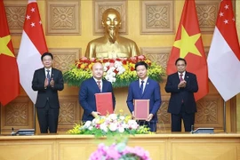 Le Premier ministre Pham Minh Chinh et le Premier ministre singapourien Lawrence Wong assistent à la remise d'un mémorandum de coopération entre des organisations des deux pays. Photo : VNA