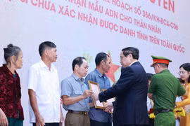 Le Premier ministre Pham Minh Chinh remet les avis de résultat d’expertise ADN des restes de martyrs aux représentants de leurs familles. Photo : VNA