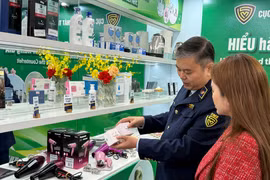 Guider une femme à distinguer des cosmétiques authentiques de produits contrefaits. Photo : Vietnam+