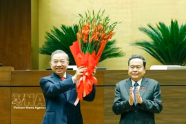 Le président de l’Assemblée nationale, Tran Thanh Man, offre des fleurs de félicitations au secrétaire général du Parti et président de l’État, To Lam, au nom des dirigeants du Parti, de l’État et des députés de la 16e législature. Photo : VNA