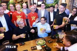 Le Premier ministre Pham Minh Chinh et Jensen Huang, fondateur et directeur général du groupe NVIDIA, dégustent la cuisine de rue à Hanoï dans la soirée du 5 décembre 2024. Photo: VNA