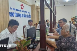 Des personnes viennent effectuer des démarches administratives lors du premier jour de mise en place du modèle d'administration locale à deux niveaux dans le quartier de Phuoc Thang, à Hô Chi Minh-Ville. Photo : VNA