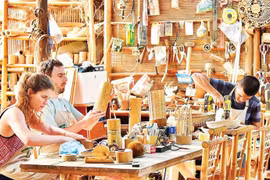 Des touristes fabriquent leurs propres souvenirs en bambou dans un atelier d'artisanat à Da Nang. Photo : nhandan.vn