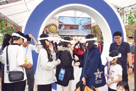 Des jeunes découvrent le festival de Co Loa et le site de l’ancienne citadelle de Co Loa dans un espace numérique. Photo : nhandan.vn