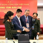 Des reporters travaillent au Centre de presse du 14e Congrès national du Parti. Photo: VNA