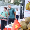 Deux touristes se font photographier avec des durians lors d'un événement vietnamien promouvant ce fruit savoureux. Photo: VNA