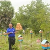 Nguyên Trung Thành montrant une ruche d'abeille dans son jardin. Photo: VNA