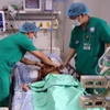 Des médecins examinent l'état de santé d'un des patients intoxiqués au botulisme sous surveillance médicale à l'Hôpital pour femmes et enfants de Dà Nang. Photo : VNA