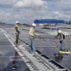 Des techniciens intallent des panneaux solaires sur des toitures à Cà Mau (Sud). Photo: VNA