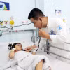 Un médecin de l'Hôpital pour enfants n°1 de Hô Chi Minh-Ville examine un enfant atteint du syndrome pieds-mains-bouche. Photo : VNA