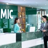 Une employée de la Military Insurance Company (MIC) discute avec des clients dans ses bureaux. Photo : mic.vn