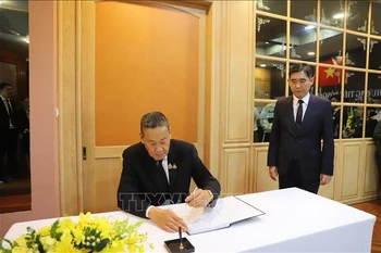 Le Premier ministre thaïlandais, Srettha Thavisin, écrit dans le registre de condoléances. Photo: VNA