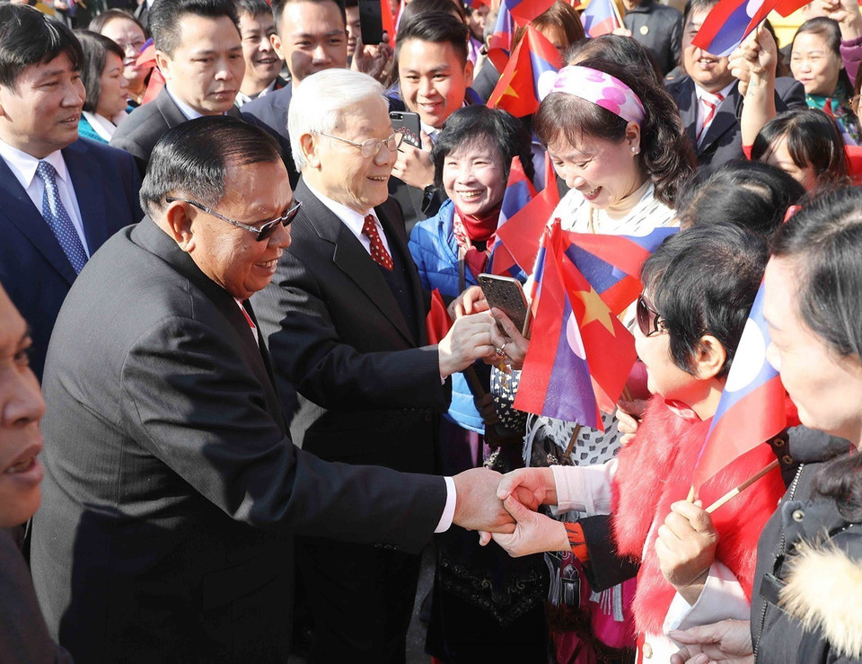 Le secrétaire général du PCV, Nguyen Phu Trong, et le secrétaire général du PPRL et président du Laos, Bounnhang Vorachith, avec des habitants de Hanoï, le matin du 19 décembre 2017. Photo: VNA