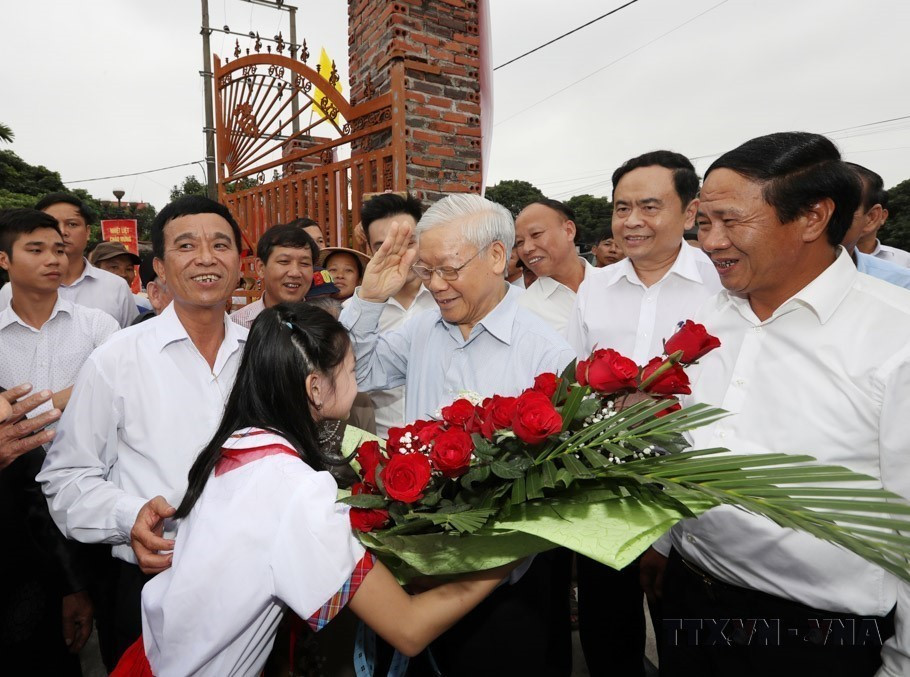 Un enfant du village de Thuong Dien, commune de Vinh Quang, offrent des fleurs pour accueillir le secrétaire général Nguyen Phu Trong participant à la Fête de grande union nationale dans la ville de Hai Phong, le 15 novembre 2017. Photo: VNA