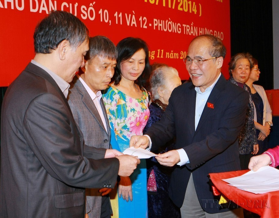 Le président de l'Assemblée nationale, Nguyen Sinh Hung, offre des cadeaux aux familles culturelles exemplaires lors de la Fête de grande union nationale entre les zones résidentielles n° 10, 11 et 12, quartier de Tran Hung Dao, à Hanoï (2014). Photo : VNA