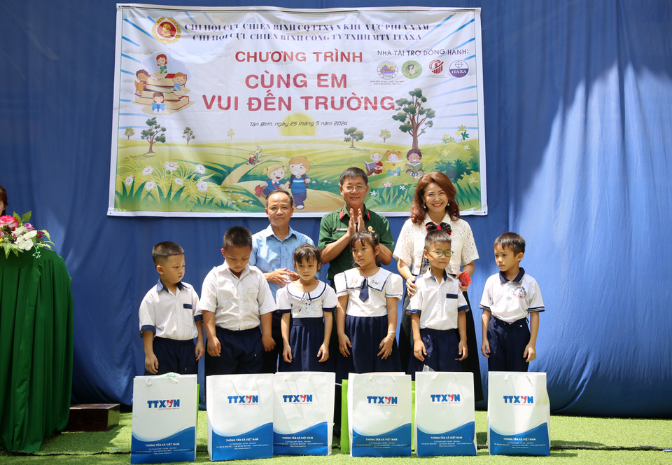 Tran Trang Duong (au milieu), président de l'Association des anciens combattants de l'Agence vietnamienne d'information, et Huynh Thi Mong Tuyen, directrice de la Sarl du commerce et de l'import-export Yamamoto-Huynh, remettent des cadeaux à des élèves.