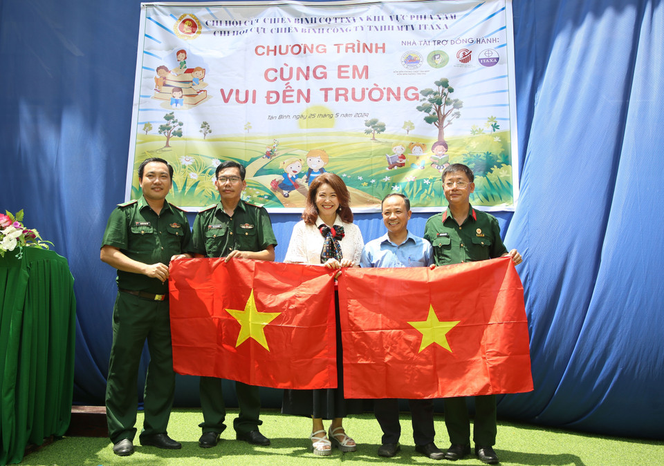 Remise de drapeaux nationaux aux représentants d'écoles et des gardes-frontières du district de Tan Bien.