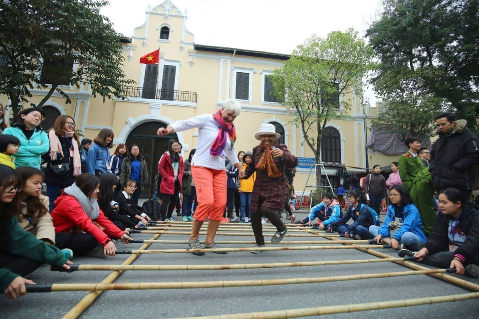 Des visiteurs internationaux participent à des activités culturelles dans la rue piétonne au tour du lac Hoan Kiem (Epée restituée) à Hanoï. Photo : VNA