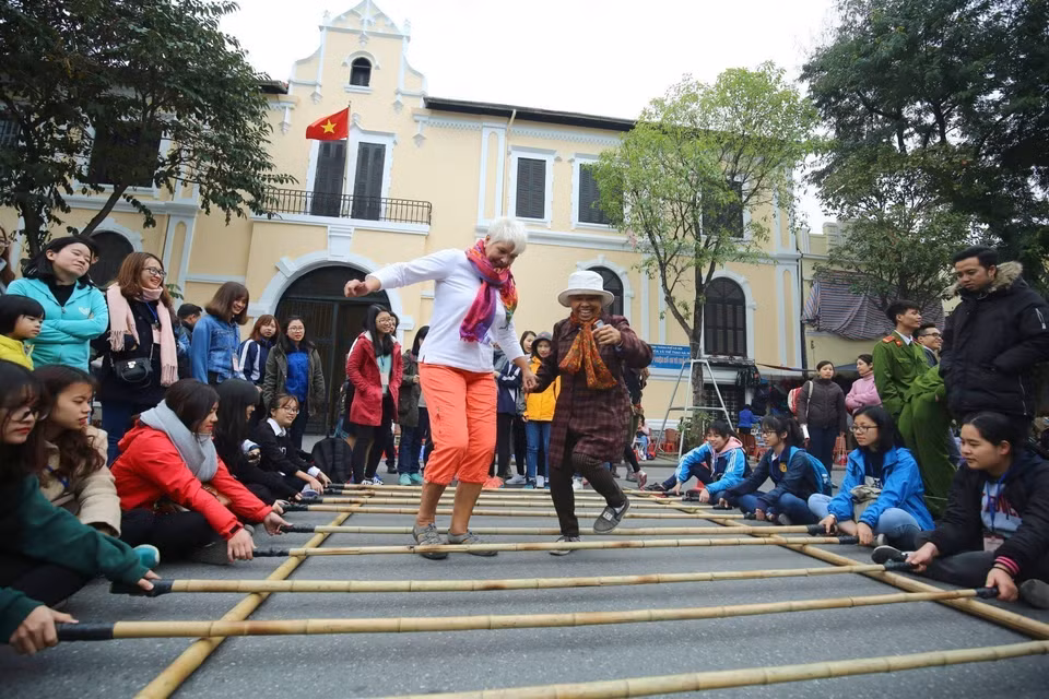Des visiteurs internationaux participent à des activités culturelles dans la rue piétonne au tour du lac Hoan Kiem (Epée restituée) à Hanoï. Photo : VNA