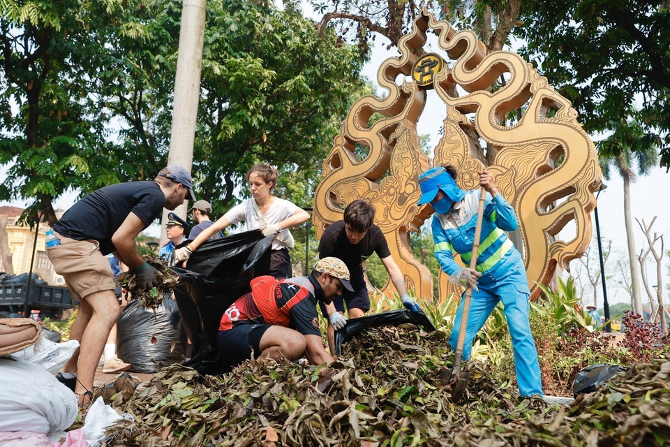 Des volontaires étrangers s'associent aux forces de nettoyage et d'assainissement de l'environnement dans l'arrondissement de Hoan Kiem. Photo: VNA