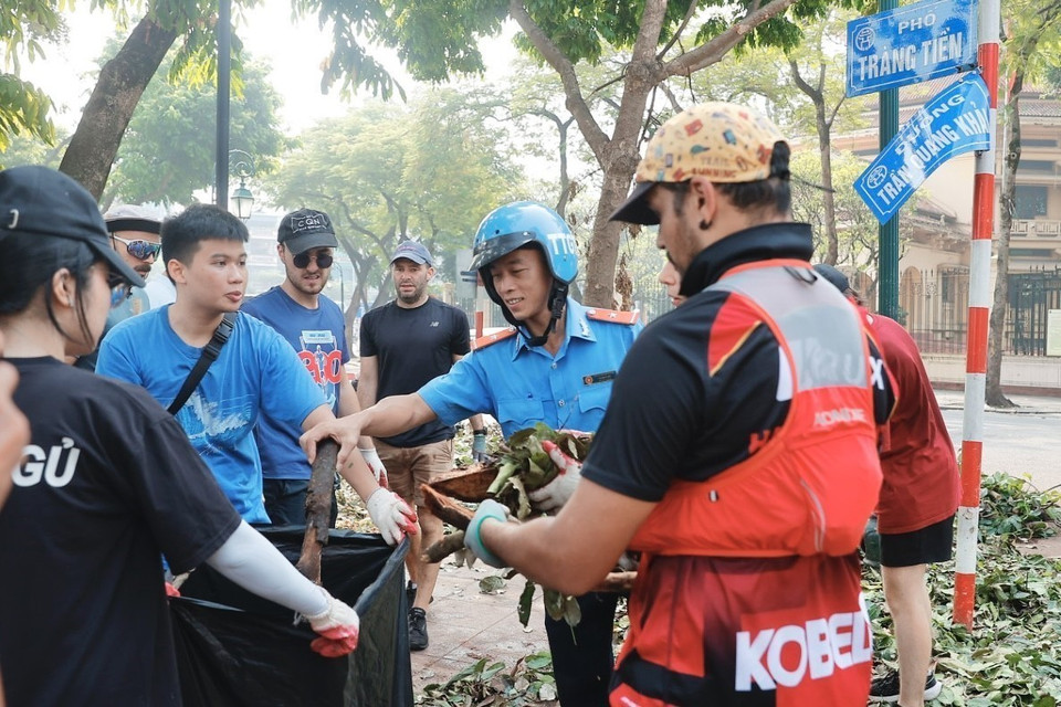 Des volontaires étrangers s'associent aux forces de nettoyage et d'assainissement de l'environnement dans l'arrondissement de Hoan Kiem. Photo: VNA