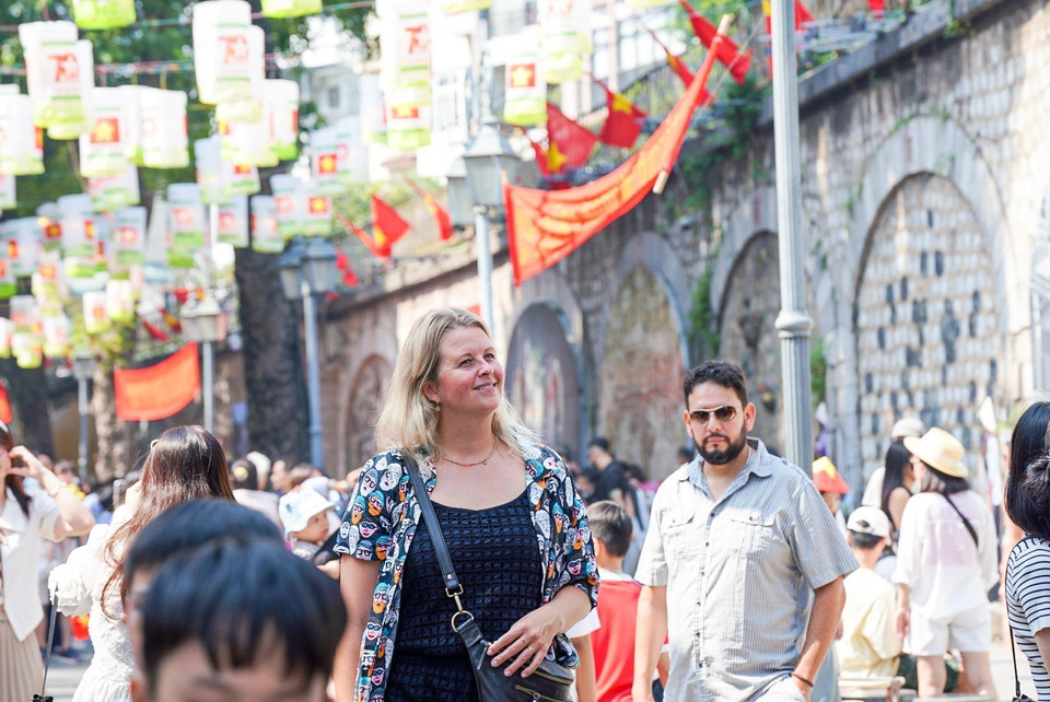 Les touristes aiment prendre des photos souvenirs dans la rue Phung Hung.