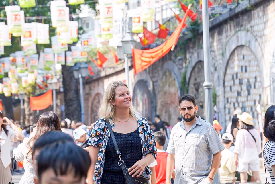 Les touristes aiment prendre des photos souvenirs dans la rue Phung Hung.