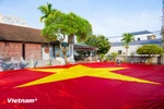 Dans le hameau de Giap Long, commune de Chuong Duong, l’atelier de Nguyên Van Trung s’affaire à achever un drapeau national géant de 600 m². Photo : Vietnam+