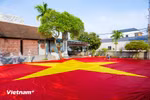 Dans le hameau de Giap Long, commune de Chuong Duong, l’atelier de Nguyên Van Trung s’affaire à achever un drapeau national géant de 600 m². Photo : Vietnam+
